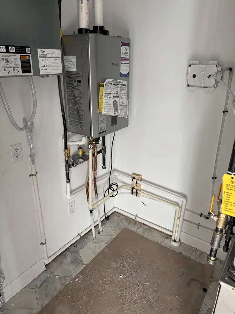 Wall-mounted mechanical equipment with connected copper and plastic piping in a finished utility room.