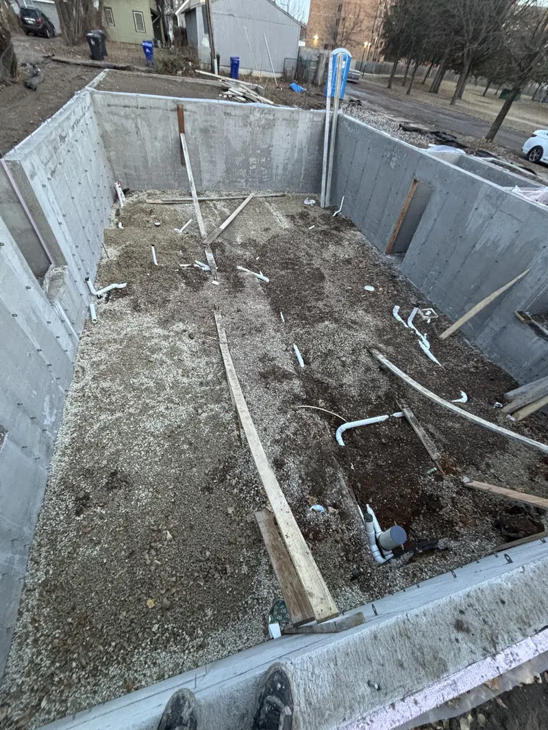 White PVC drain and vent piping installed inside a residential foundation before the slab.