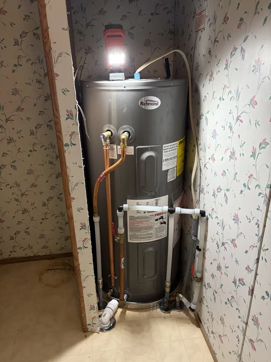 After: replacement electric water heater in the same utility closet.
