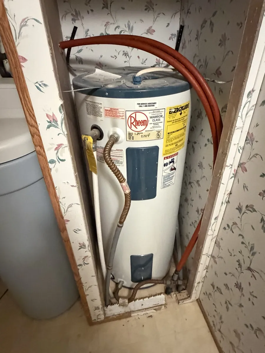 Before: existing electric water heater before replacement.