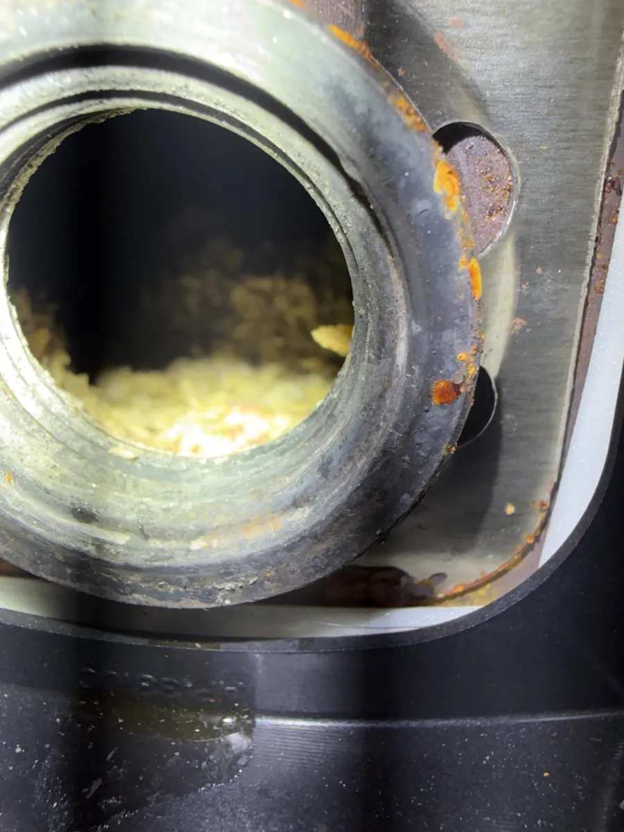 Sediment visible at the element opening during electric water heater service.