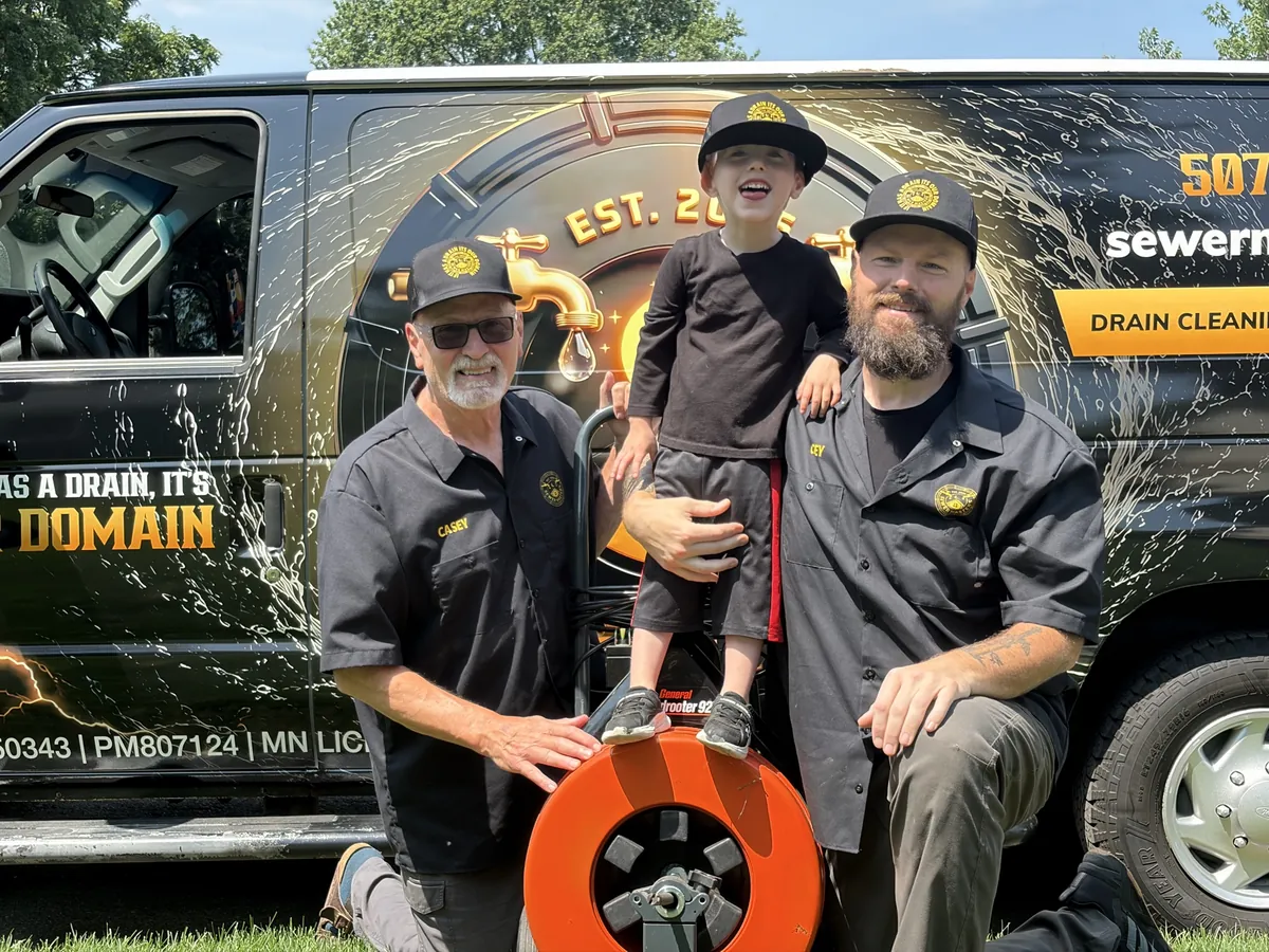 Casey with his son and father in front of the Sewer Masters service van