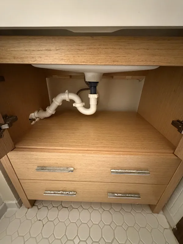 New P-trap and drain plumbing installed under a bathroom vanity sink