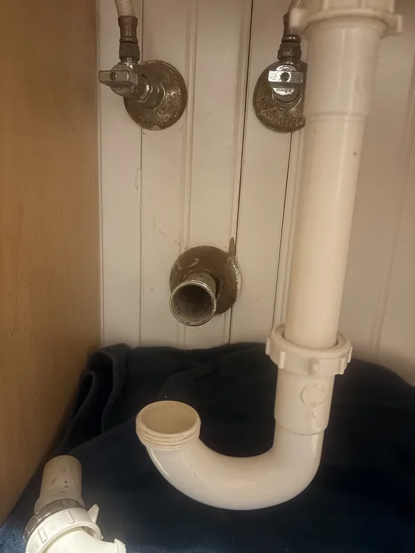 Sink shutoff valves and drain trap installed under a bathroom cabinet