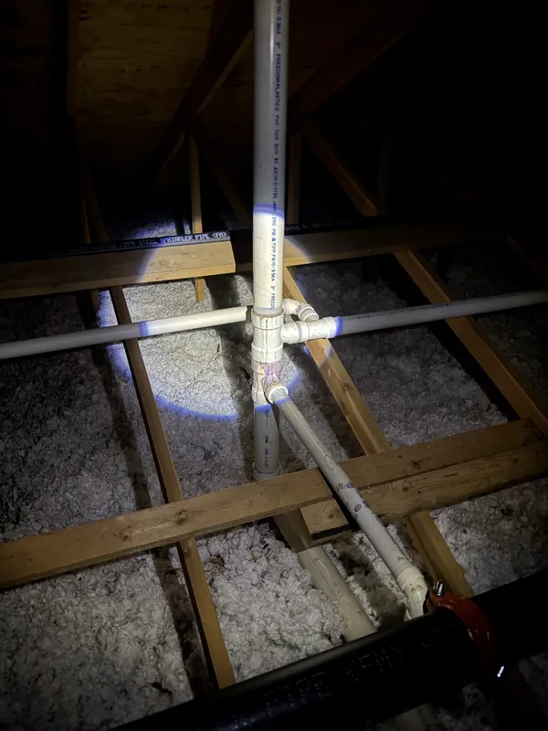New PVC water supply piping run through attic framing during a repipe